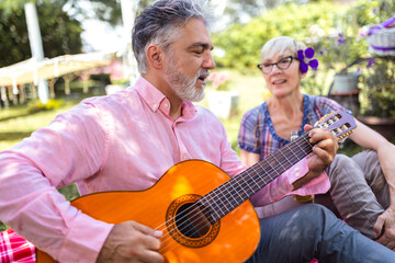 Loving mature couple with guitar in park