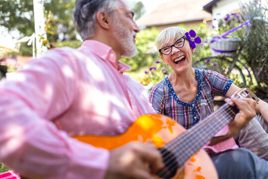 Music, guitar and a senior couple on picnic in park, romance in retirement. - Powered by Adobe