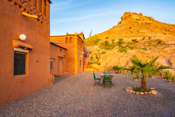 Clay buildings and gardens of traditional riad kasbah guesthouse at sunrise in Ait Ben Haddou...