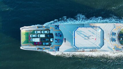 Passenger ferry boat with cars on deck cruising in sea. Sea logistics and transportation. Aerial top down view