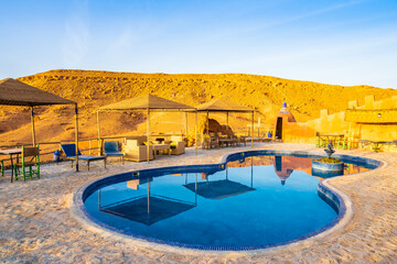 Swimming pool in traditional riad kasbah guesthouse at sunrise in Ait Ben Haddou village, Morocco, North Africa