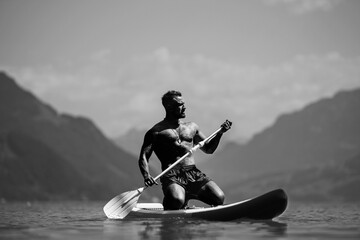 Male fit muscular model with paddle board. Guy paddling on paddleboard. Healthy summer lifestyle....
