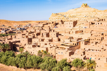 View of Ksar Ait Ben Haddou, old Berber adobe-brick village or kasbah in green oasis with palm trees, Ouarzazate, Morocco, North Africa