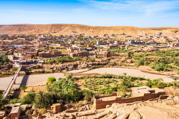 View of Ait Ben Haddou, old Berber ancient village or kasbah with river and green oasis with palm...