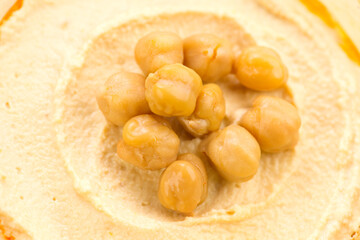 Hummus with dripping olive oil background, hummus texture close-up, rotation backdrop. Healthy vegan food. Top view