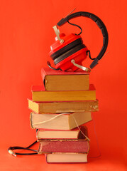 Large heap of books and heaphone, audio books concept, entertainment,education and e learning on...