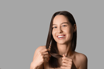 Young dark-haired woman on grey background