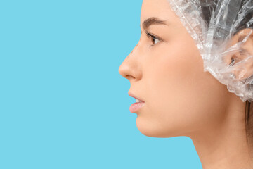 Young woman in medical hat with marks on her nose before plastic surgery against blue background,...