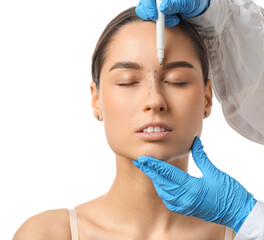 Doctor in protective gloves drawing marks on woman's nose for plastic surgery against white...
