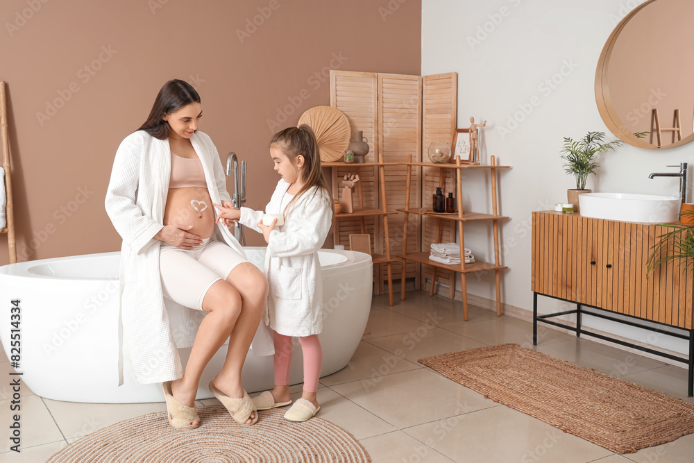 Sticker Little girl with her pregnant mother applying cream on belly in bathroom