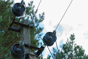 An oil transformer and power lines in the forest. The support of an overhead power line. Natural...