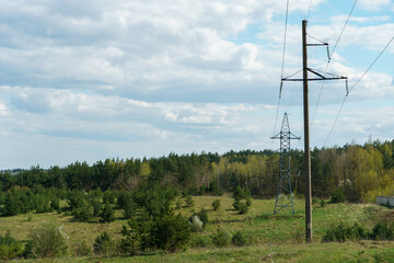 Power lines running through the forest. The support of an overhead power line. Natural landscape and technological progress.