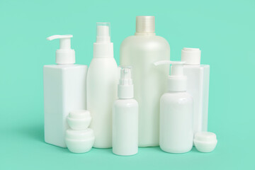 Different cosmetic products on green background