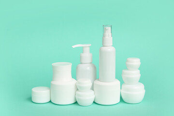 Different cosmetic products on green background