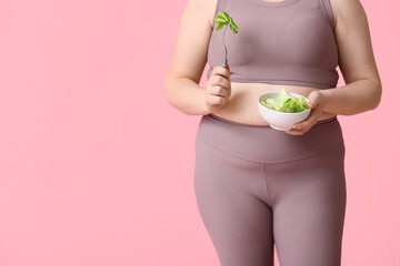 Overweight woman with salad on pink background. Diet concept