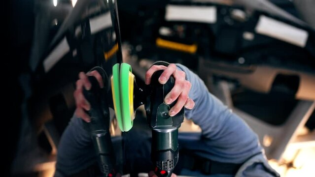 vertical video close-up of the hands of a car mechanic at a service station doing the final polishing to shine