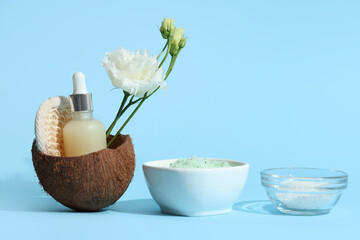 Bowl of natural body scrub, sea salt, essential oil and flowers on color background