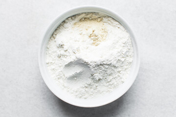 All purpose flour and vital wheat gluten in a ceramic bowl, process of making bread flour