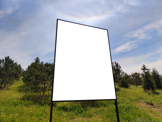 Mockup of Blank Billboard in Grassy Field under Clear Blue Sky: Rural Setting with Tree Line, Sunny...