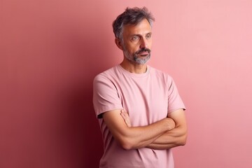 Fototapeta premium A man in a pink shirt is standing in front of a pink wall