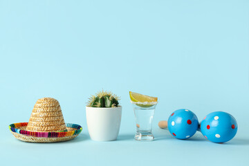 Cactus with Mexican maracas, sombrero and tequila on blue background. Cinco de Mayo