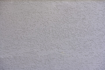 Close-up of a gray textured plaster wall surface, showcasing a rough, detailed pattern ideal for backgrounds.
