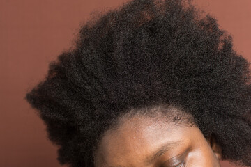 Black afro curly hair with shrinkage, Type 4c hair that is dry with a brown background