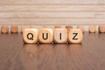 the text QUIZ is written on wooden cubes on a brown background
