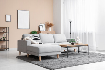 Interior of stylish living room with grey sofa, coffee table and picture