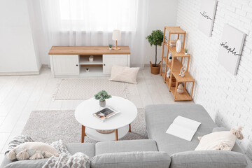 Fototapeta premium Interior of stylish living room with comfortable sofa, bench, coffee table and shelving unit