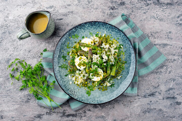 Traditional steamed green asparagus with goat cheese and pistachios served as top view on a Nordic...