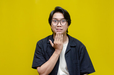 asian young students happily using sign language isolated against yellow background. asian man...