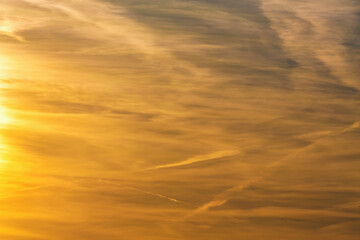 Sunset sky with golden clouds creating a serene and warm atmosphere perfect for backgrounds and...