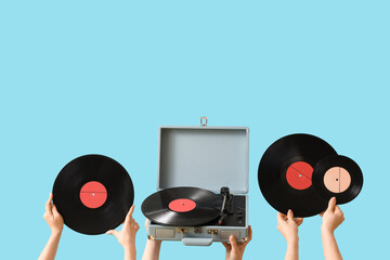 Women with record player and vinyl disks on blue background