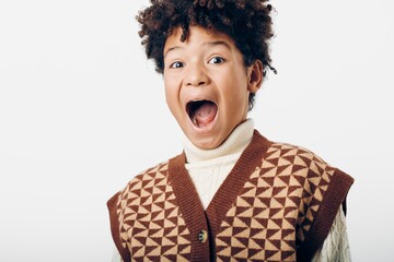 wideeyed young boy expressing amazement while dressed in a cozy sweater on a chilly day
