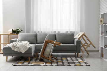 Interior of living room with grey sofa after earthquake