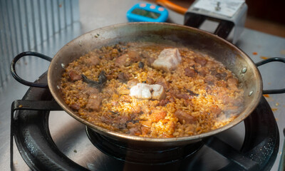 Cooking traditional Spanish paella with meat and mushrooms