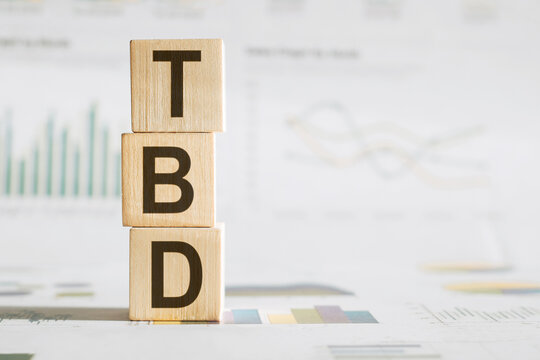 Businesswoman made word tbd with wood building blocks.