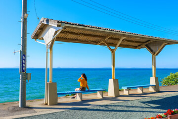 下灘駅で海を眺める女性 愛媛県