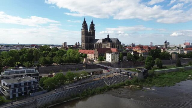 Magdeburg Skyline mit Dom und Ufer vom Fluss Elbe, Drohnen Flug mit Rotation um den Magdeburger Dom an einem sonnigen Tag im Fr&uuml;hling 