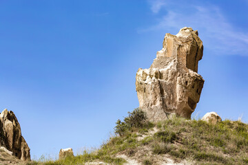 Iconic rock formation in Cappadocia under a clear blue sky, showcasing the unique geological...