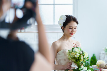 ウエディングドレスを着た花嫁を撮影するカメラマン