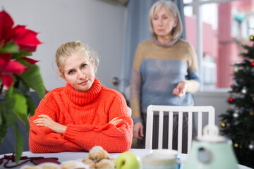 Mature woman quarrels with her adult daughter, who came to visit her before Christmas, scolding her