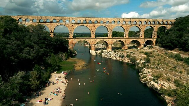 Aerial view of Pont du Gard aqueduct bridge and crowded beach of the Gardon River. Nimes, France