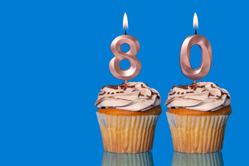 Birthday Cupcakes With Candles Lit Forming The Number 80.
