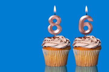 Birthday Cupcakes With Candles Lit Forming The Number 86.