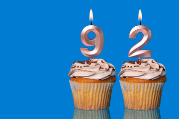 Birthday Cupcakes With Candles Lit Forming The Number 92.