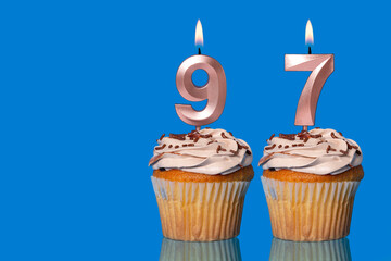 Birthday Cupcakes With Candles Lit Forming The Number 97.