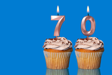 Birthday Cupcakes With Candles Lit Forming The Number 70.