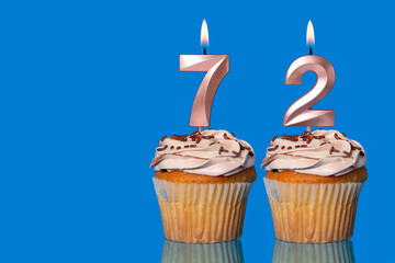 Birthday Cupcakes With Candles Lit Forming The Number 72.